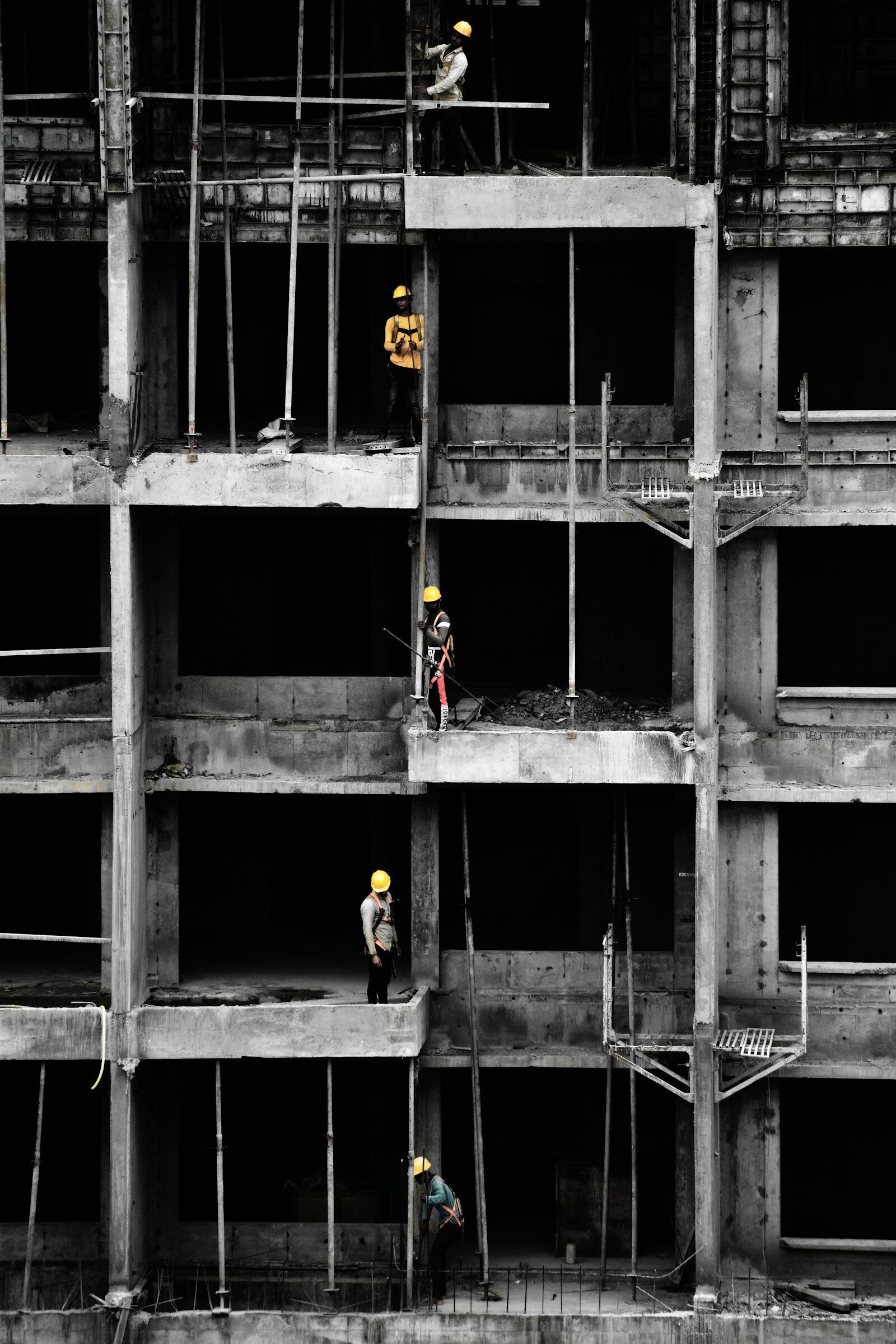 Workers in hard hats on the open floors of a building under construction